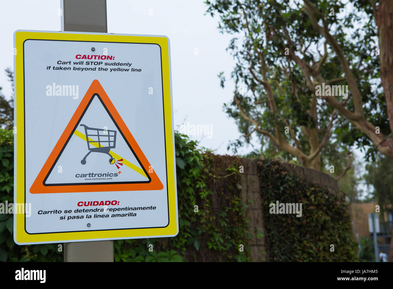 Caution carts will stop suddenly sign. Carttronics a developer of electronic systems used to stop the loss of shopping carts at retail stores, Stock Photo