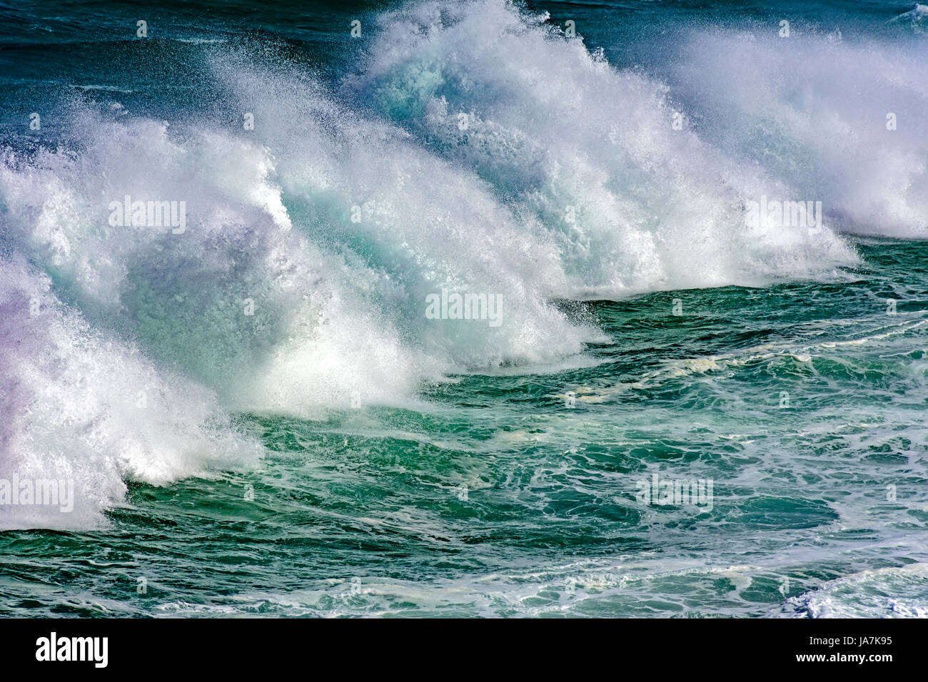 Wave crashing against rocks during storm Stock Photo