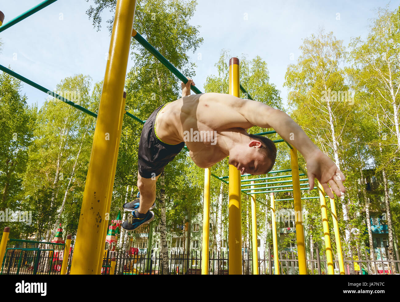 Fitness man at the bar. Exercising outdoors in the Park. Street workout Stock Photo