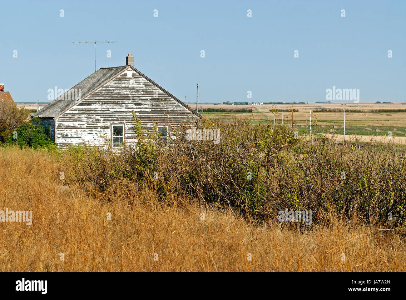 Dilapidated farm house by prairie farmland Stock Photo