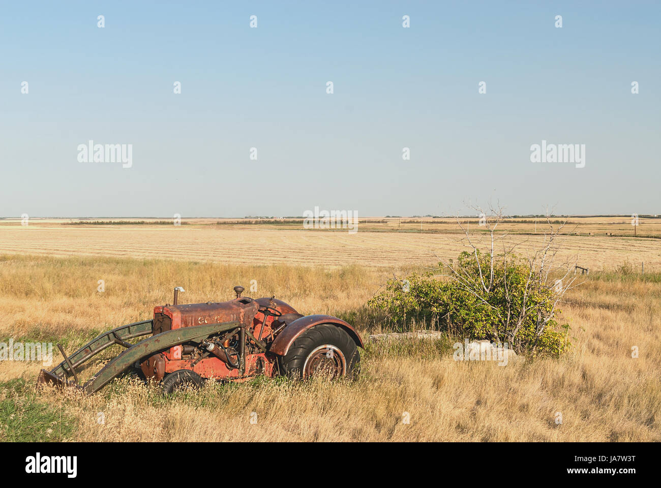 Farm equipment abandoned and rusting in field Stock Photo