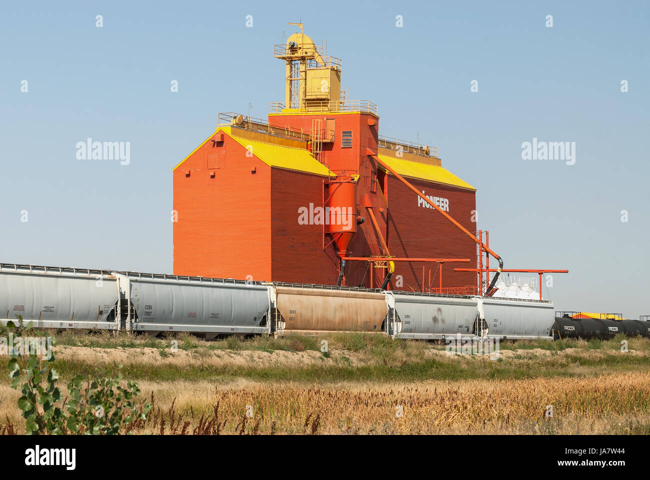 Railway siding next to brightly painted grain elevator Stock Photo