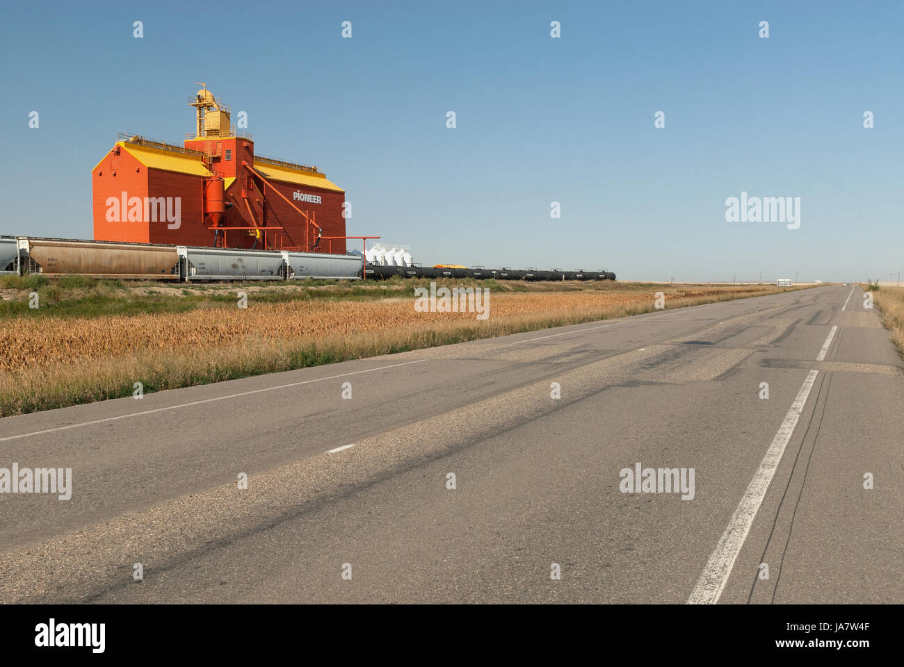 Railway siding next to brightly painted grain elevator Stock Photo