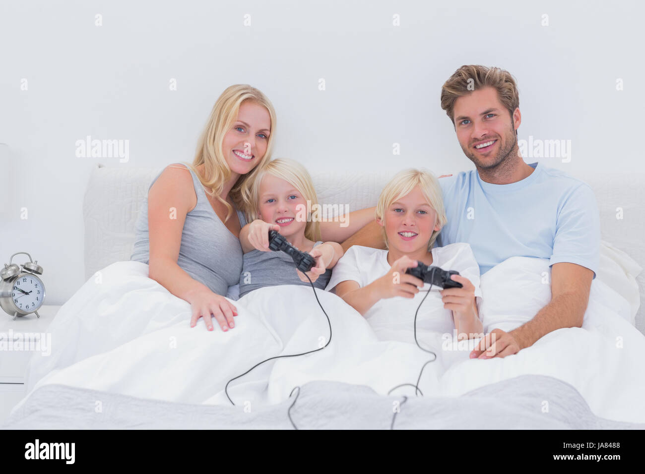 Family playing video games in bed Stock Photo Alamy