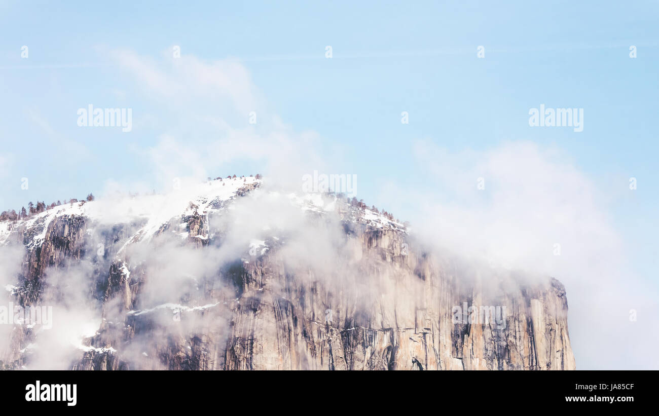 Panoramic photo of the top of Yosemite's Half Dome with scattered snow and clouds. Stock Photo