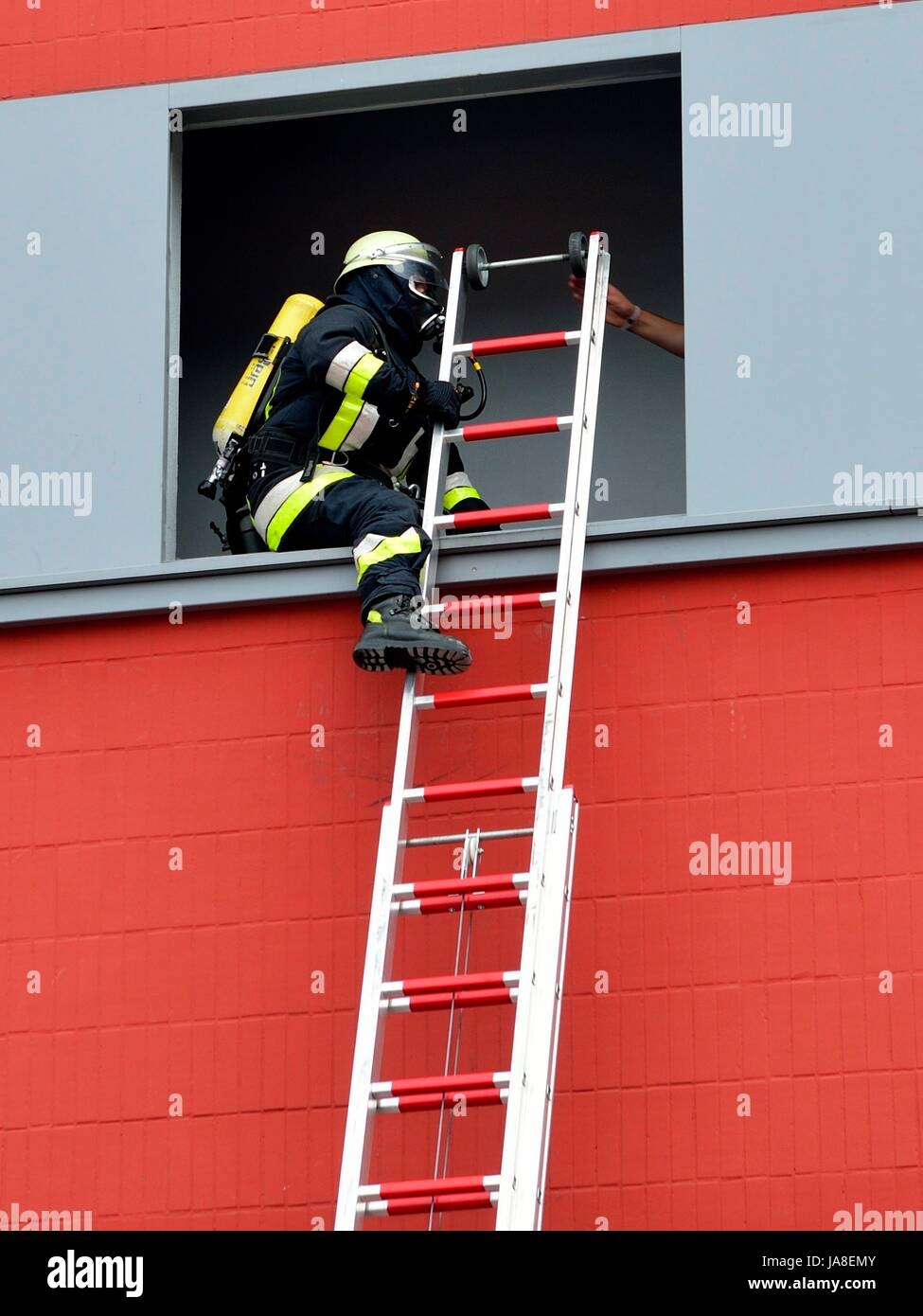 Feuerwehr: Retten, Bergen, Schützen Feuerwehrmann mit Leiter beim einsteigen in eine Fensteröffnung zur Rettung von Menschen Stock Photo