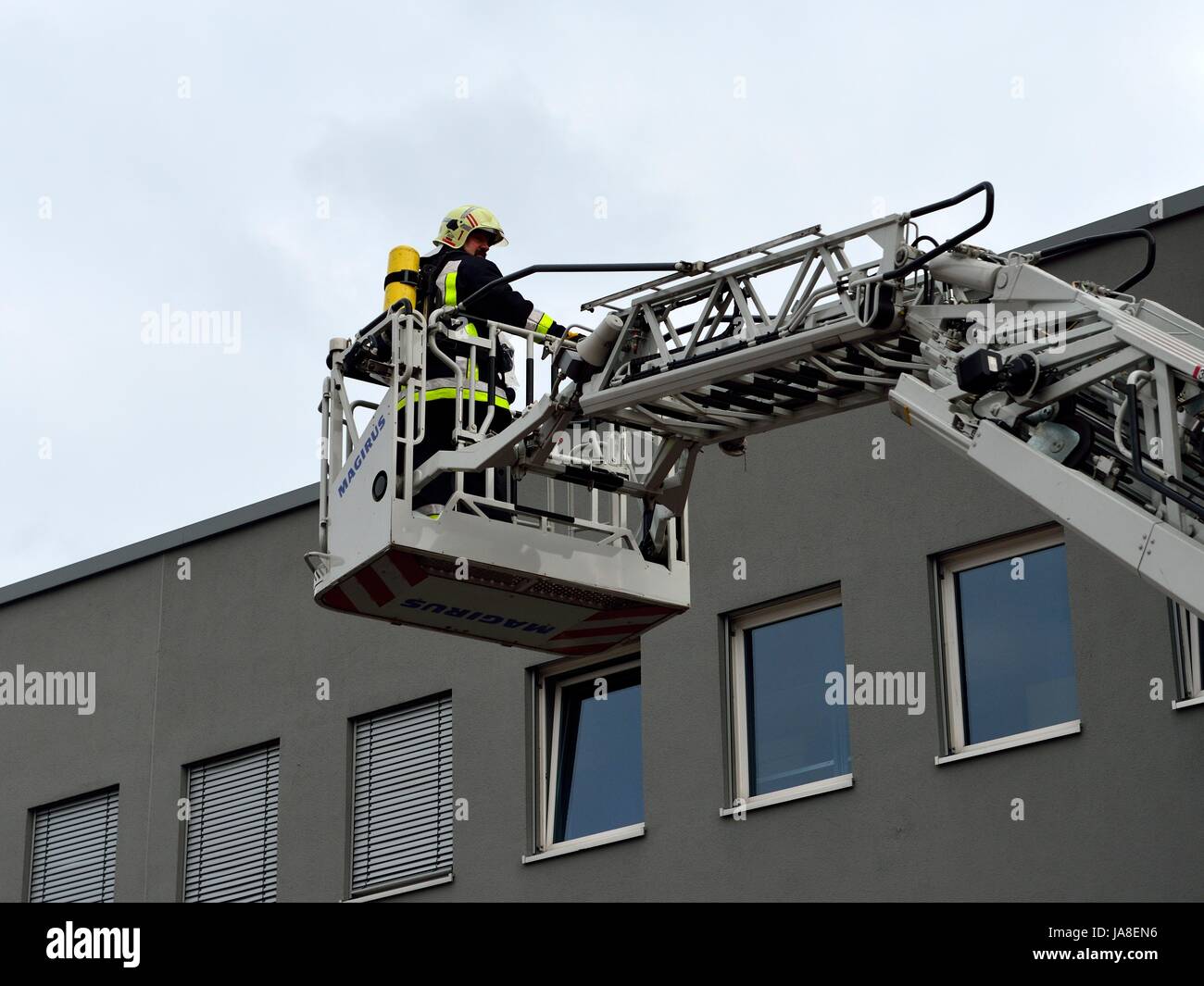 Feuerwehr: Retten, Bergen, Schützen Feuerwehrmann im Korb des Leiterwagens Stock Photo