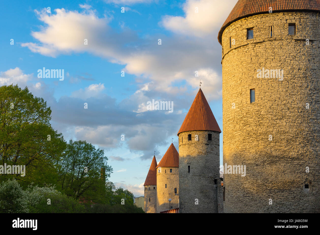 Fortress towers in a row against blue sky and clouds. Springtime evening in Tallinn, Estonia Stock Photo