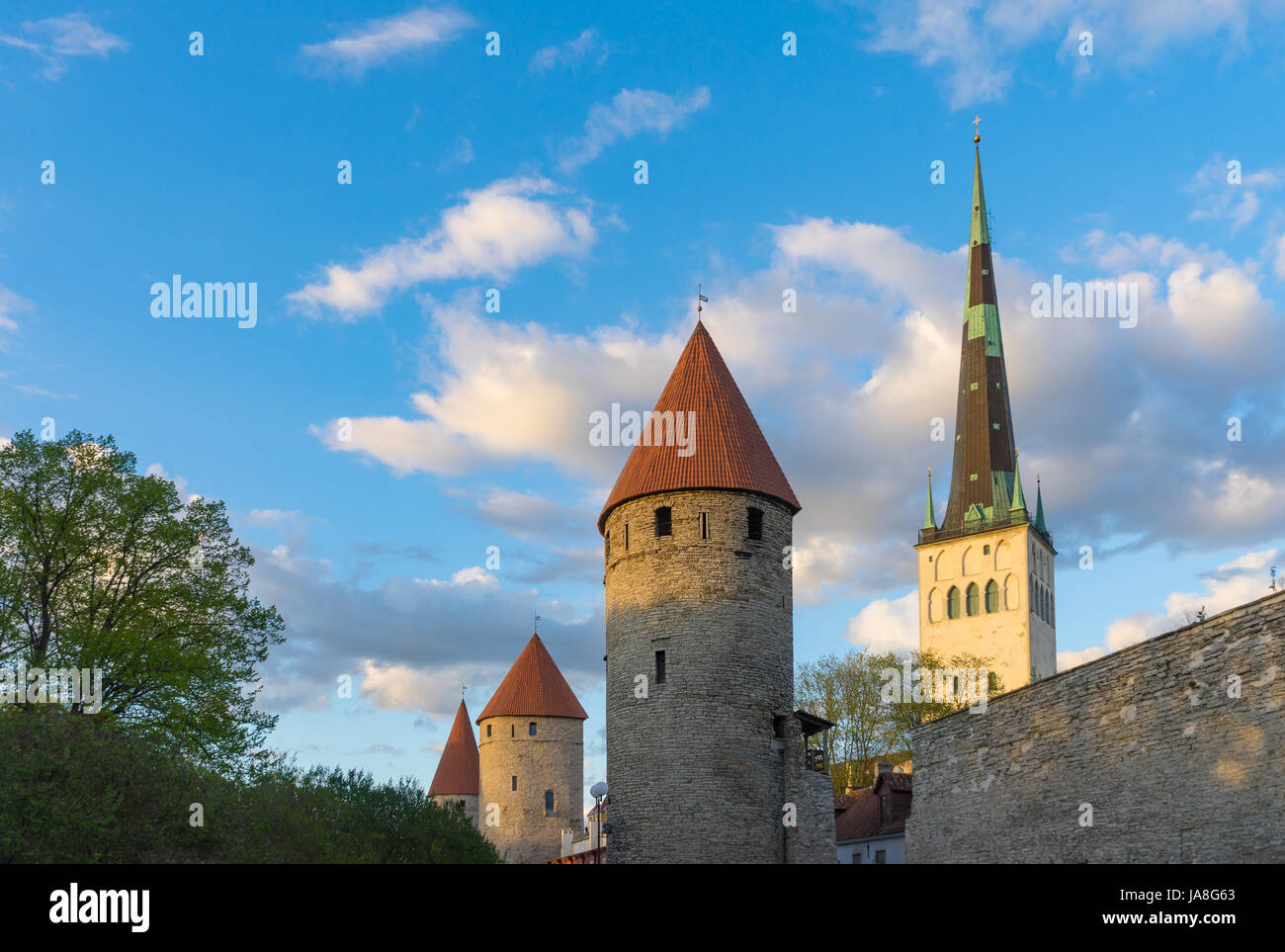 Fortress towers and St. Olaf's church against blue sky and clouds. Springtime evening in Tallinn, Estonia Stock Photo