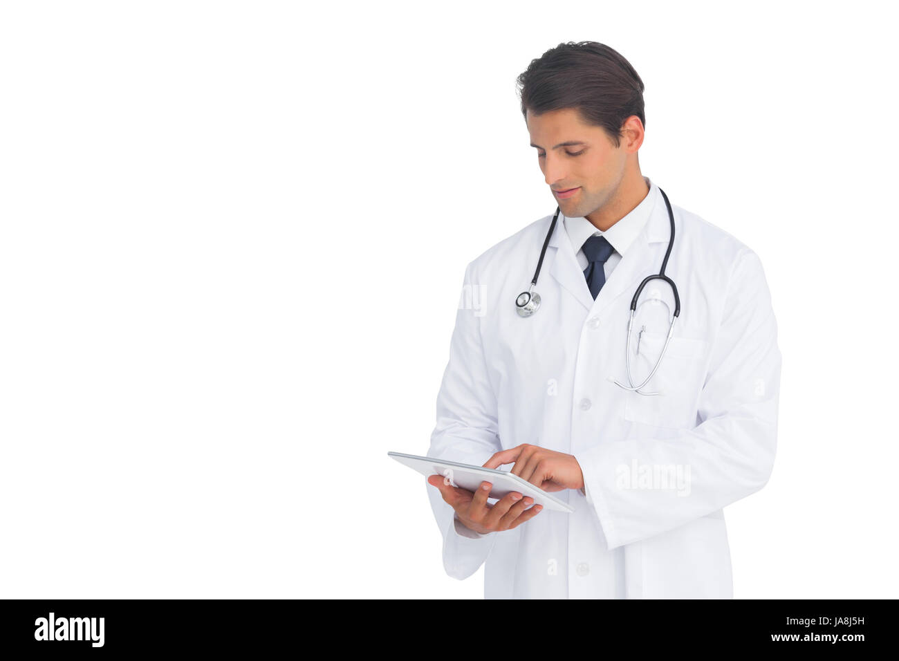 Smiling doctor using a tablet on white background Stock Photo - Alamy