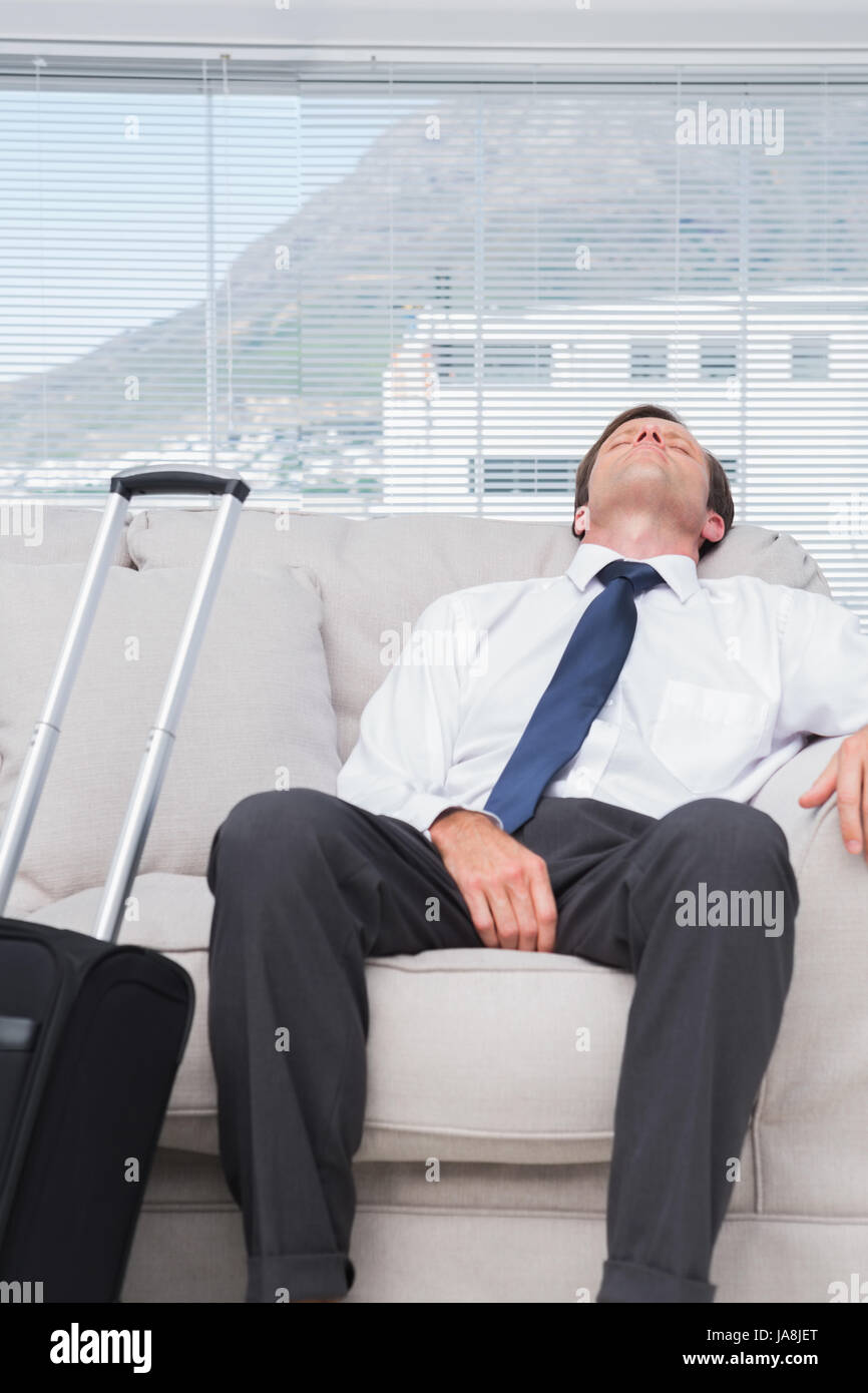 Exhausted businessman sleeping on couch Stock Photo Alamy