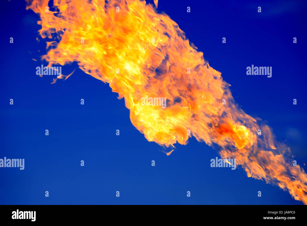 Closeup of bright fire flame on dark blue background Stock Photo
