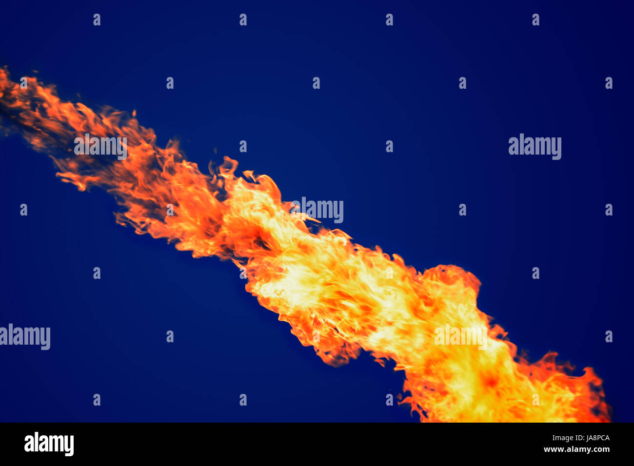 Closeup of bright fire flame on dark blue background Stock Photo