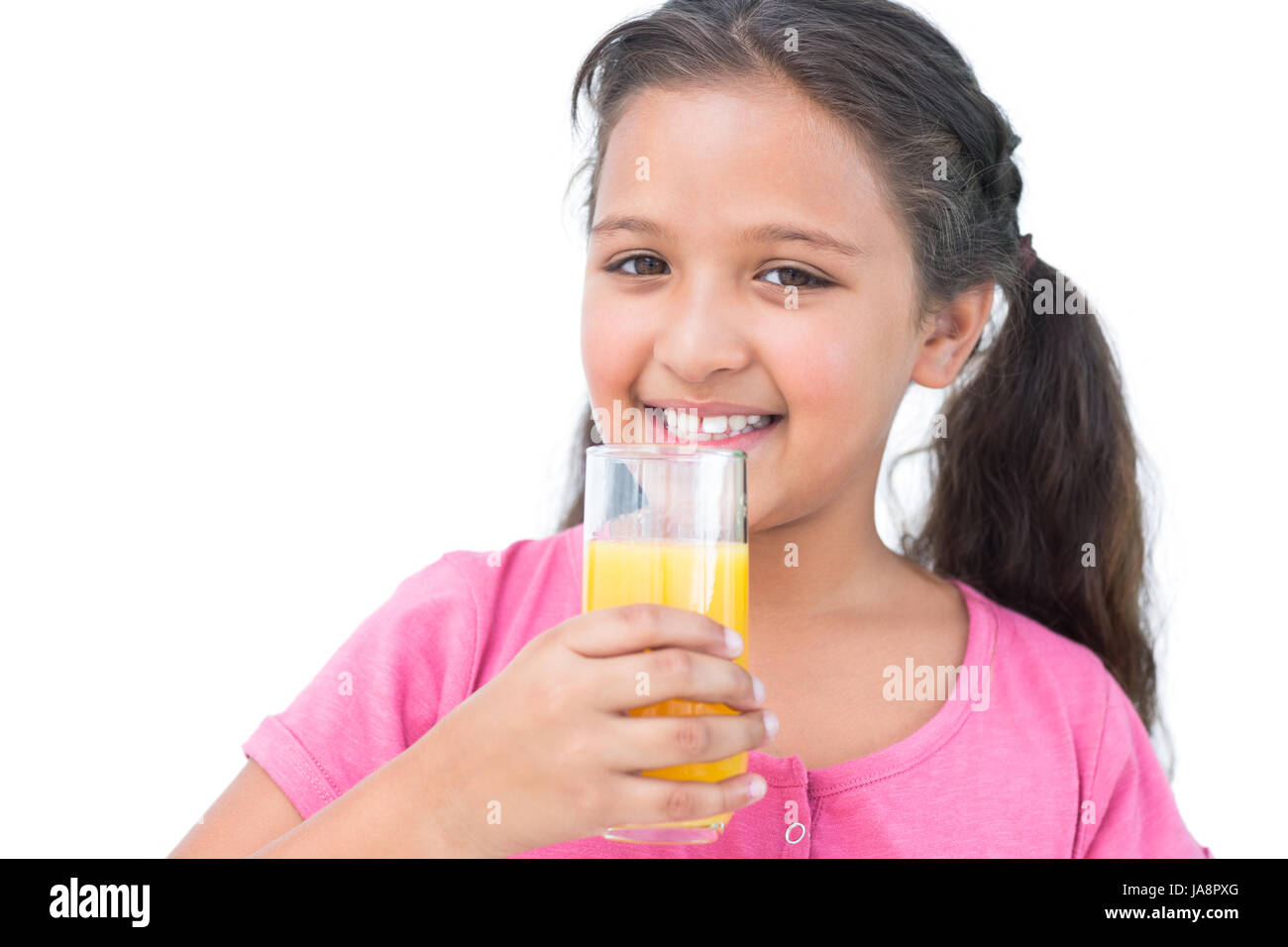 Smiling little girl drinking orange juice on white background Stock ...