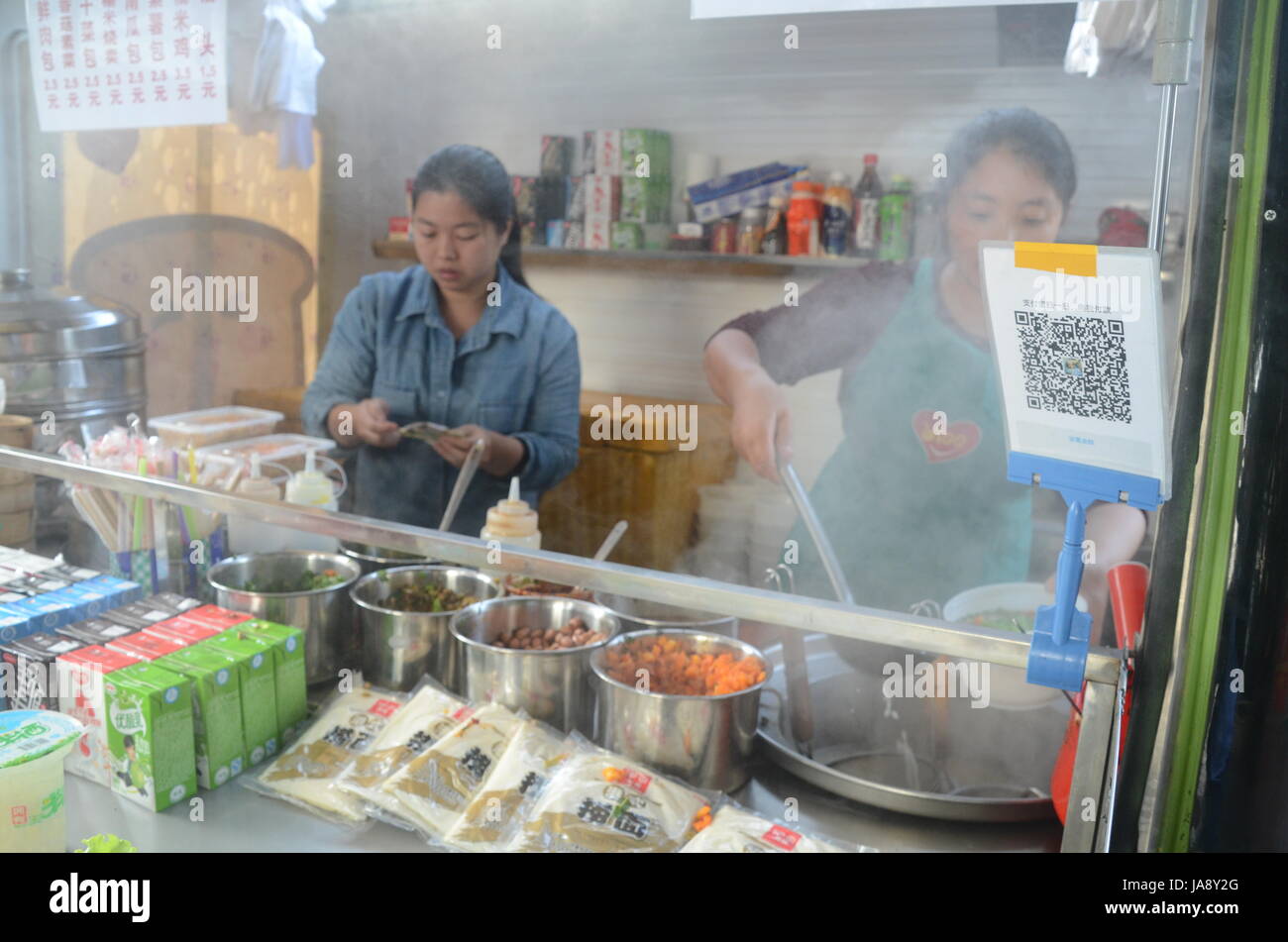 China is going cashless. People buy noodles with QR code and mobile phone, using Alipay, WeChat Wallet or other mobile wallet. Fintech is booming. Stock Photo