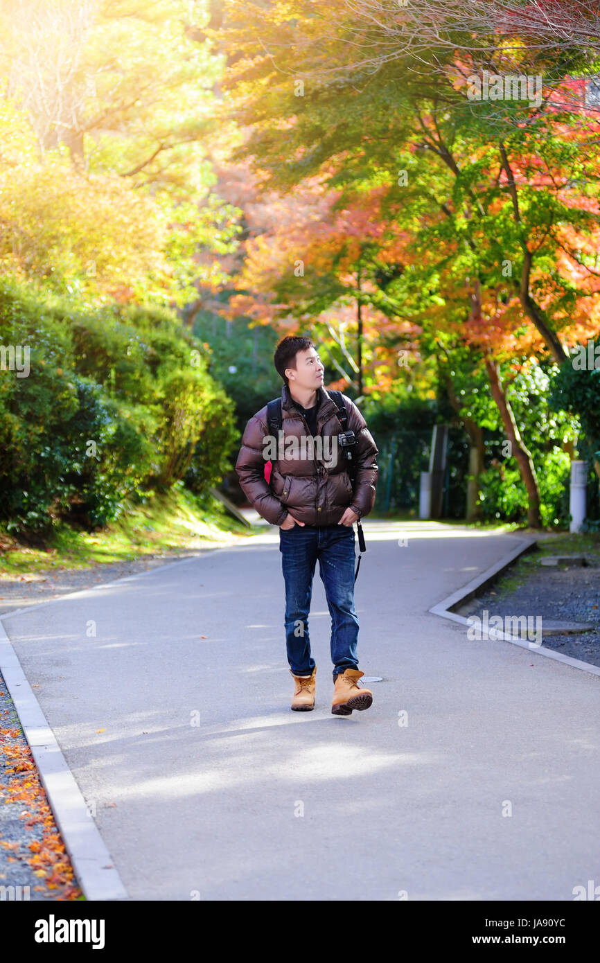 Portrait of a happy young man traveling with backpack in Autumn. Kyoto JAPAN , vintage tone filter effected Stock Photo