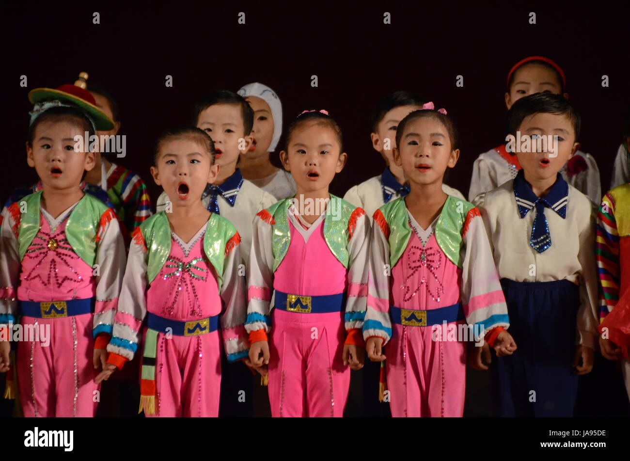 North Korea children performing music and dancing in the city of Rason. Songs hailing the 'Great' and 'Dear Leaders' Kim Il Sung and Kim Jong-Il. Stock Photo