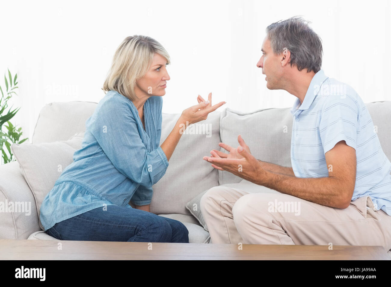 Couple having an argument at home on couch Stock Photo - Alamy