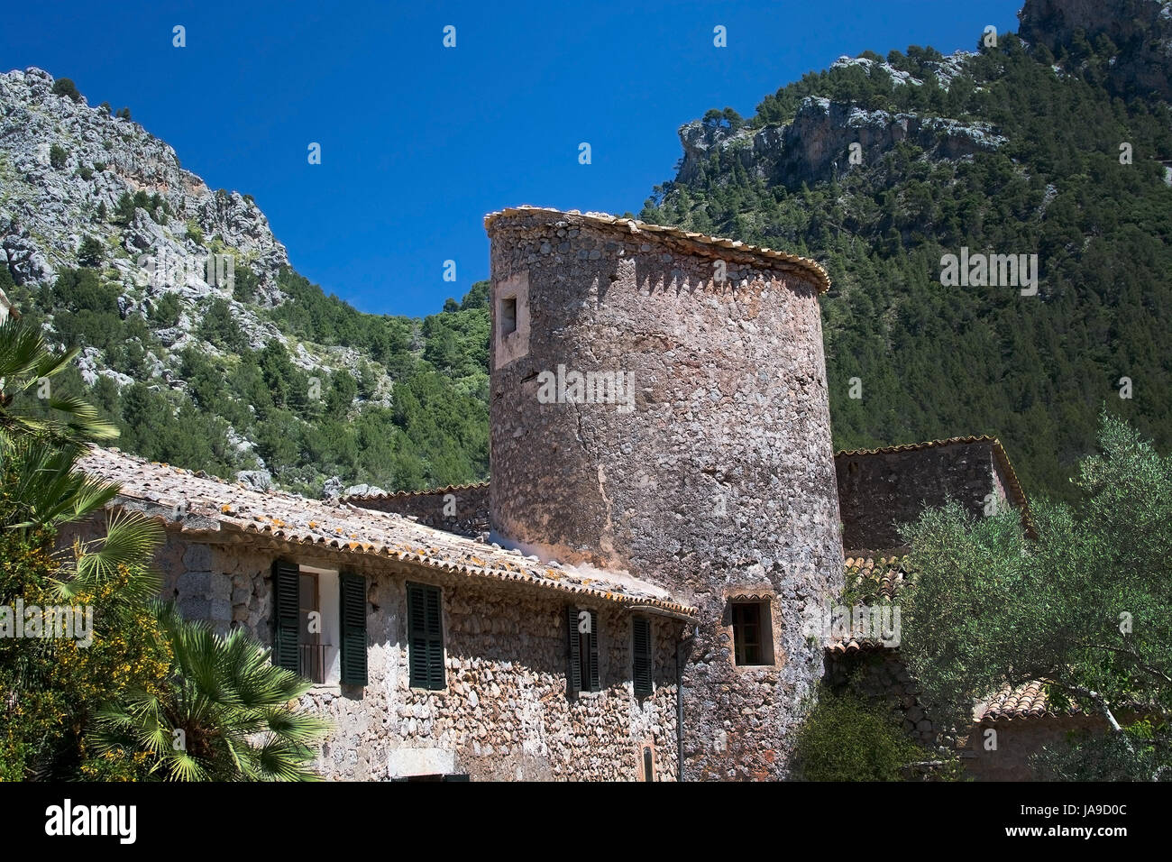 MALLORCA, SPAIN - MAY 15, 2017: Rustic stone building with tower in green subtropical garden in the Tramuntana mountains on May 15, 2017 in Mallorca,  Stock Photo