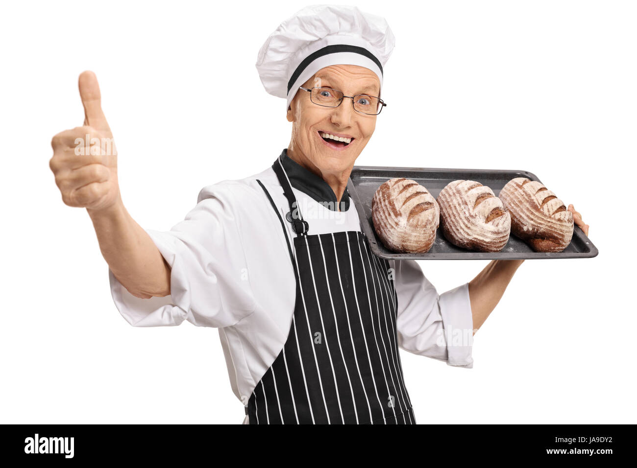 Joyful baker holding a tray with loaves of bread and making a thumb up sign isolated on white background Stock Photo