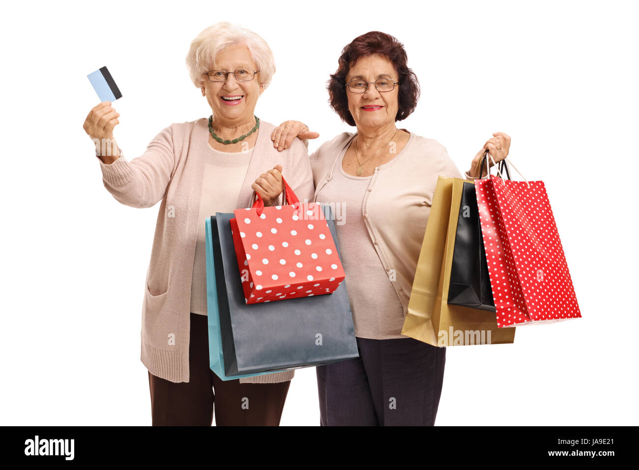 Two elderly women with shopping bags and a credit card isolated on