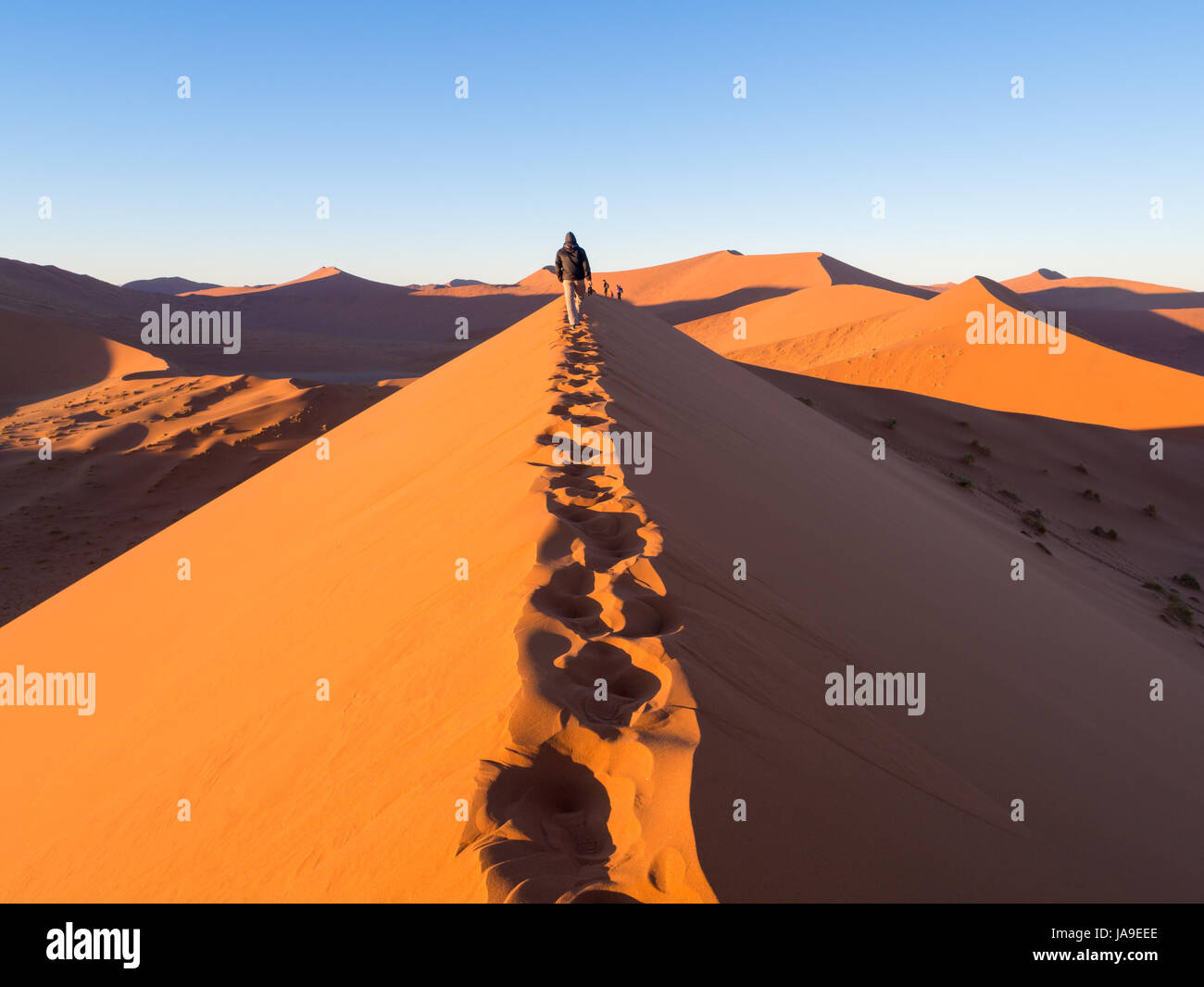 SOUSSUSVLEI, NAMIBIA - JUNE 20, 2016: People watching sunrise form the Dune 45 in the Sossusvlei area of the Namib Desert in Namibia. Stock Photo
