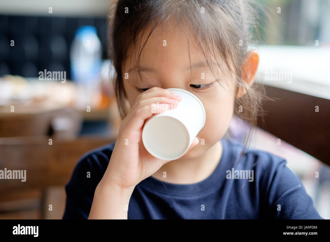 Asian kid drinks water from white paper cup Stock Photo - Alamy