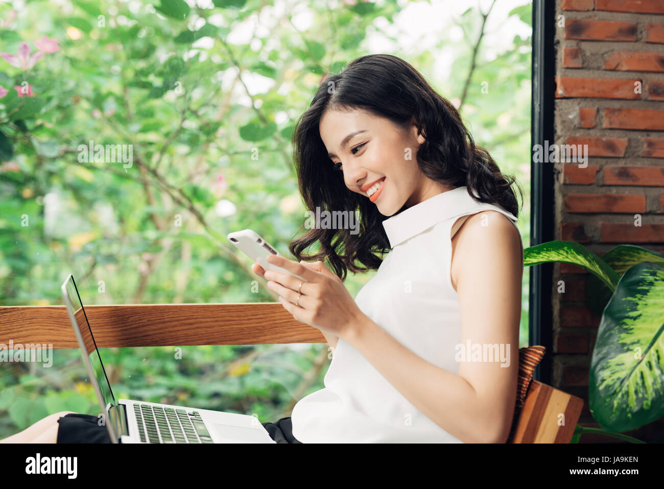 Confident young asian woman in smart casual wear using smartphone, Typing on phone. Stock Photo