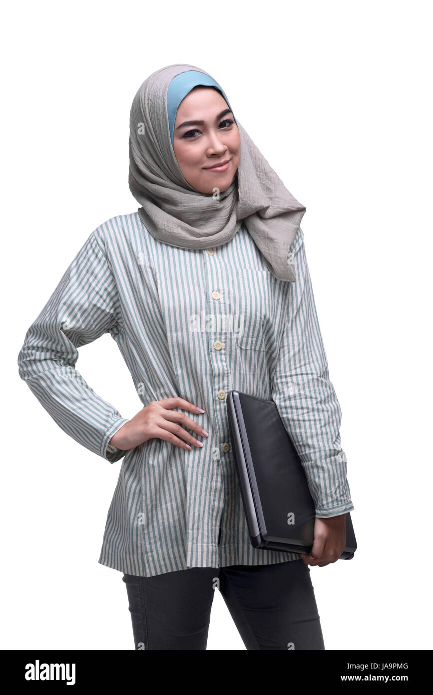 Smiling asian muslim woman holding laptop isolated over white ...