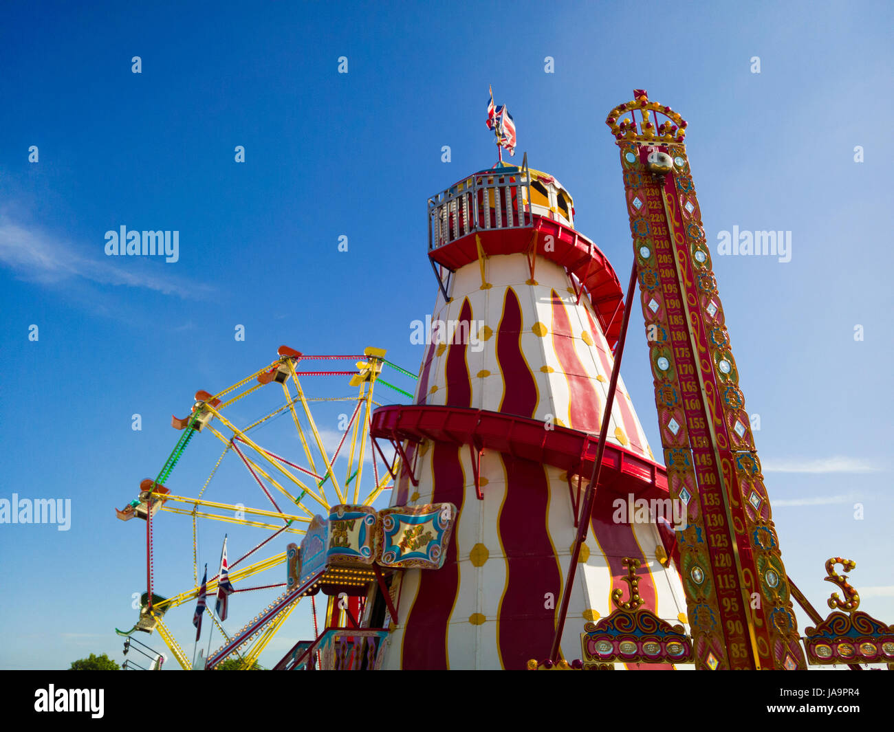 A Ferris wheel, helter skelter and a high striker game at the funfair at the Bath and West Show, Shepton Mallet, Somerset, England. Stock Photo