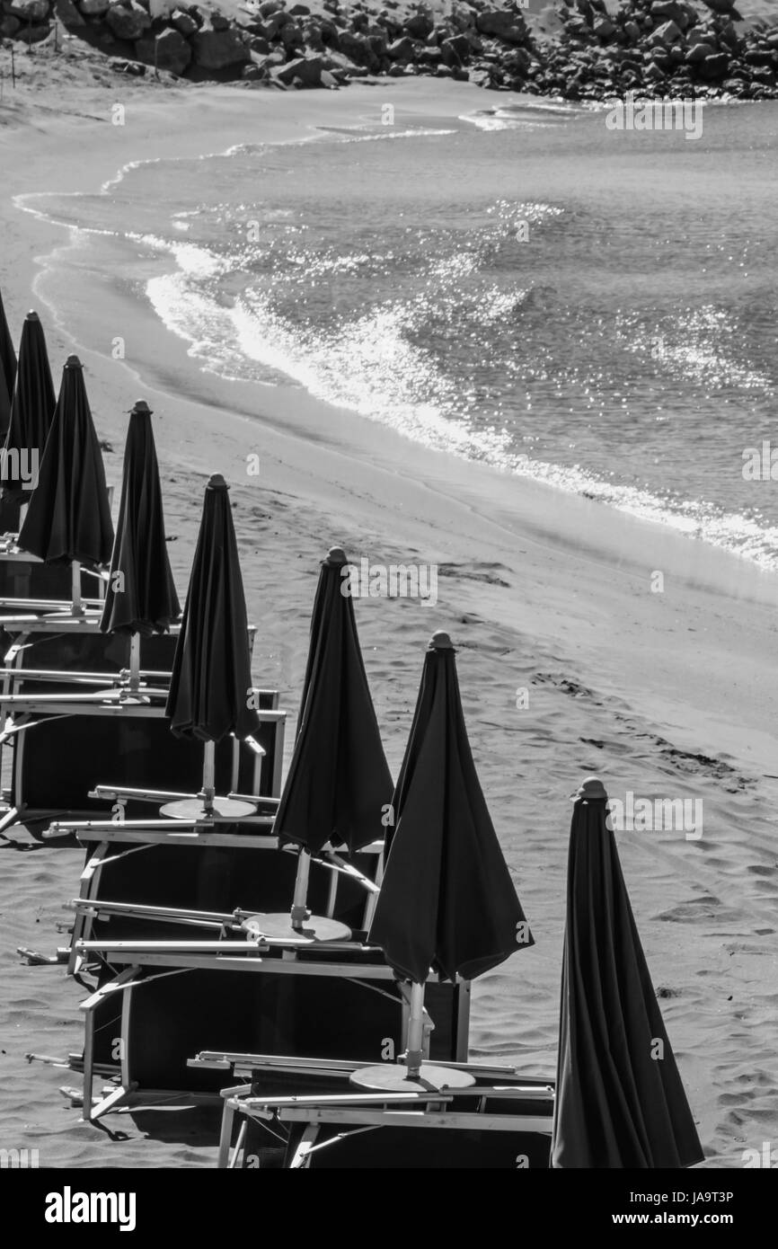 The closed beach umbrellas and chaise longue Stock Photo