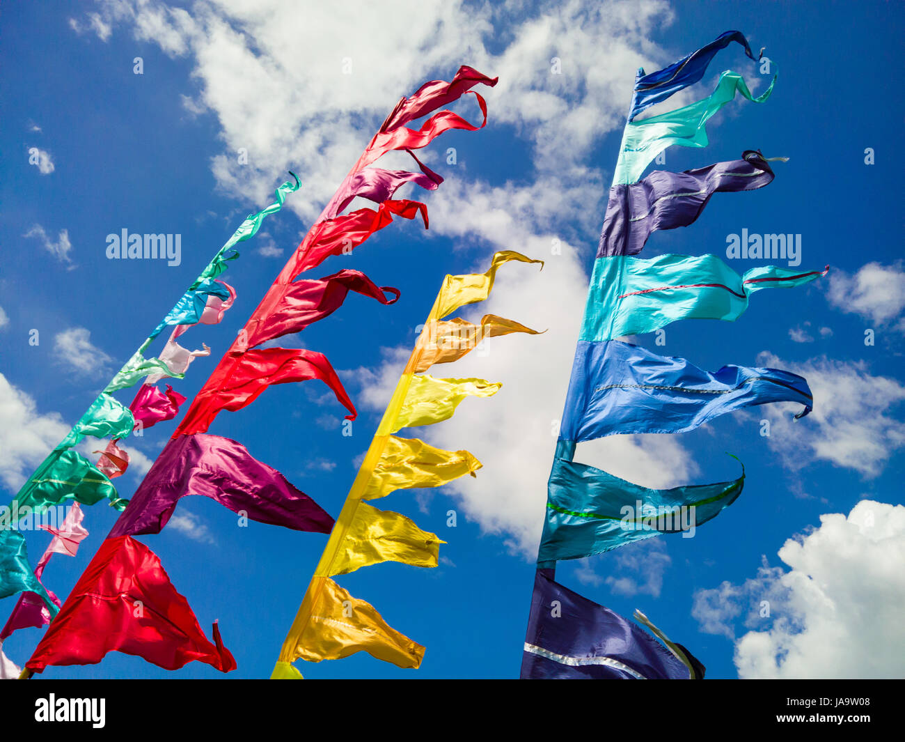 Colourful festival flags against a blue sky. Stock Photo
