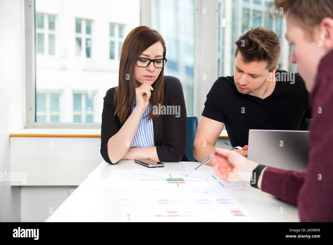 Business People Discussing Over Chart At Desk Stock Photo