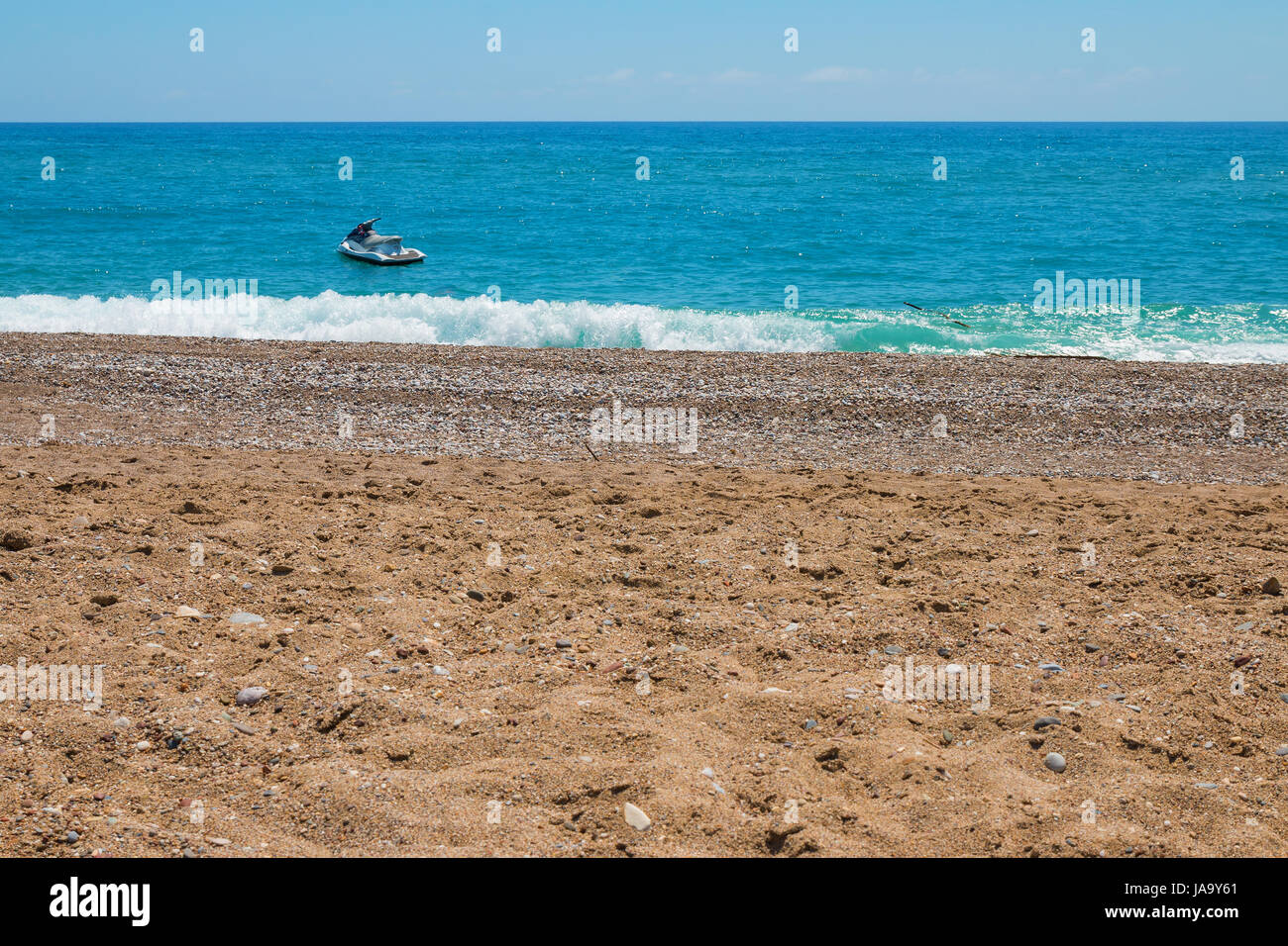 Ski jet on the calm ocean near the rocky beach Stock Photo