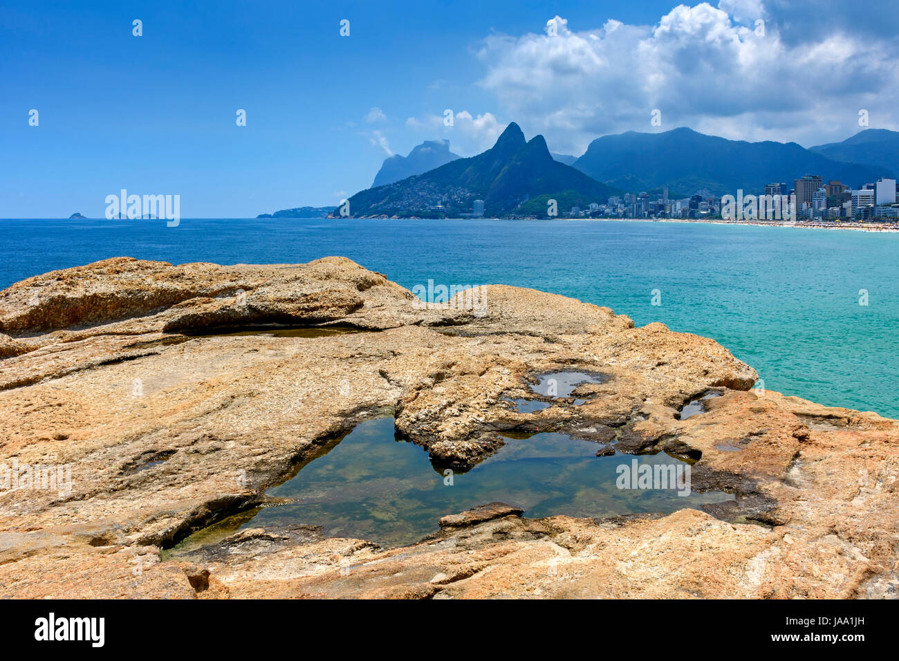 Rio de Janeiro, Ipanema beach, Gavea stone and Two Brothers hill seen through the Arpoador stones Stock Photo