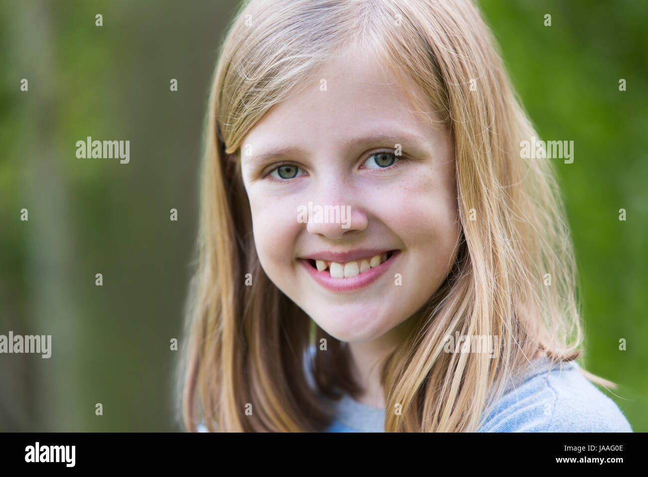 Portrait Of Smiling Pre Teen Girl Outdoors Stock Photo