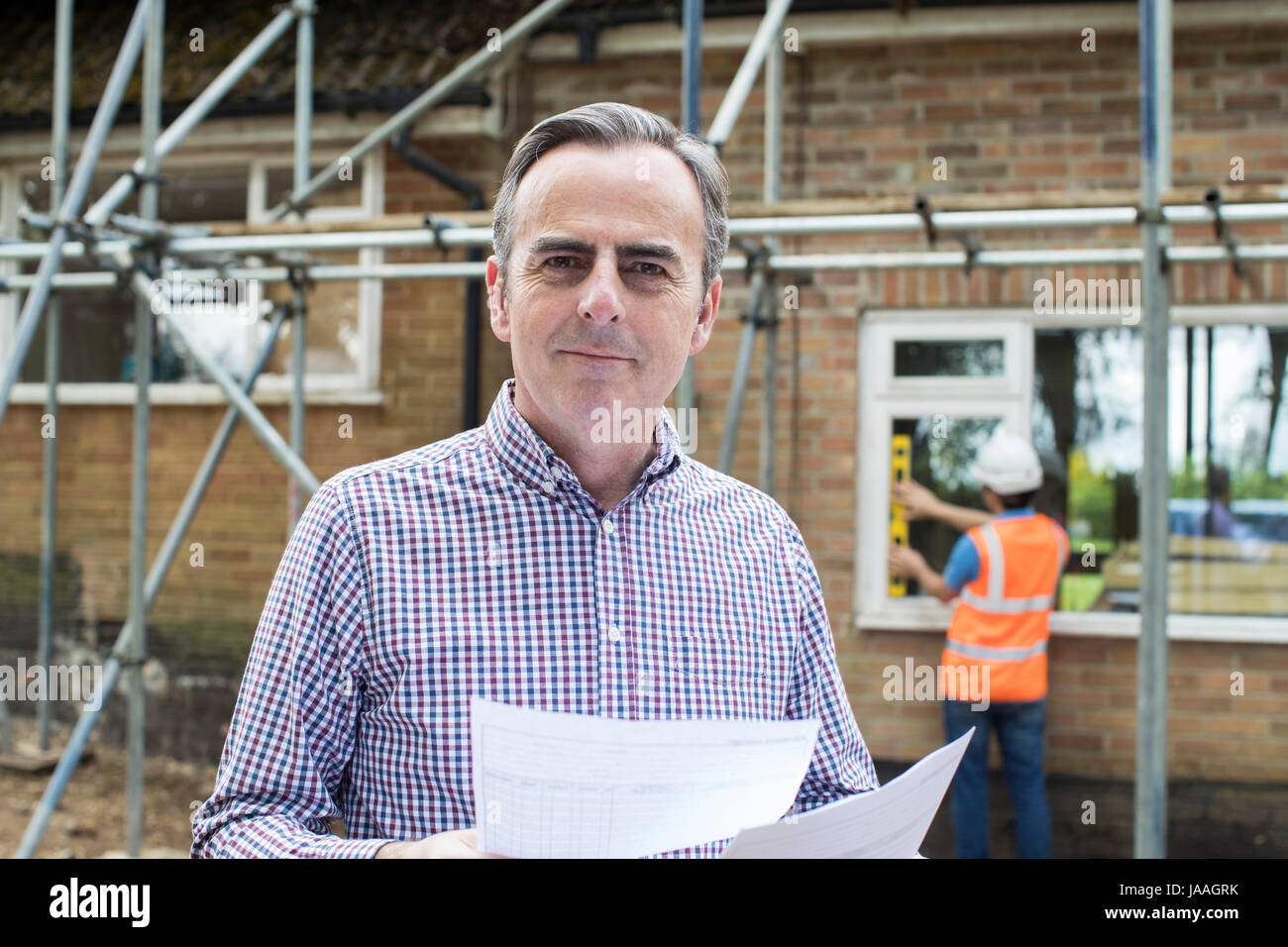 Satisfied Client Looking At Bills For House Building Work Stock Photo