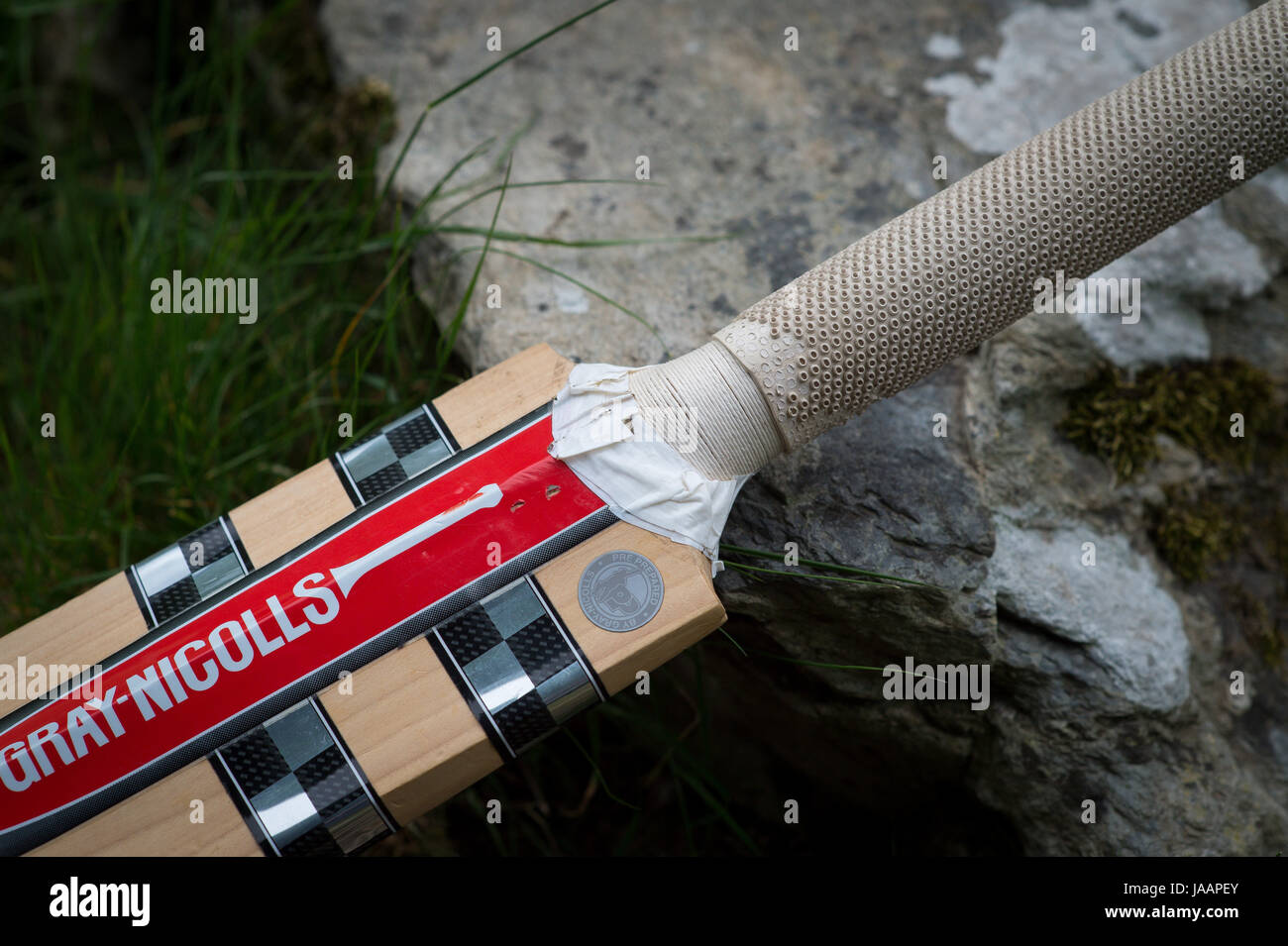 A cricket bat has white tape near the splice at Lynton & Lynmouth