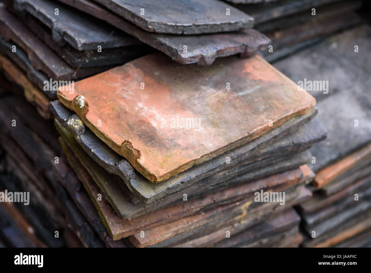 A pile of old reclaimed terracotta roof tiles. Stock Photo