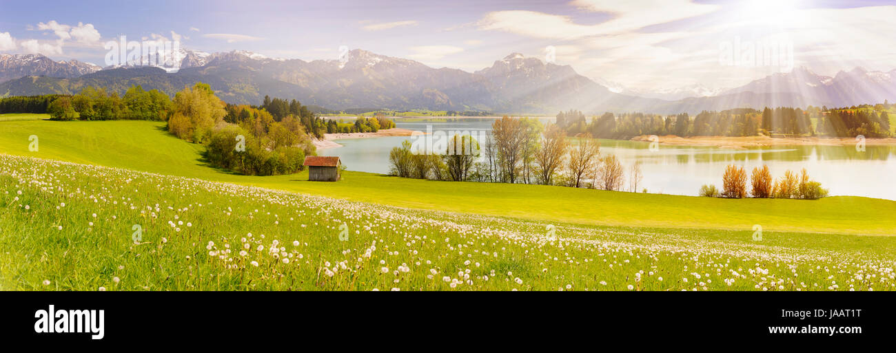 panorama scene in Bavaria, Germany at alps mountains with sunbeams over lake Stock Photo