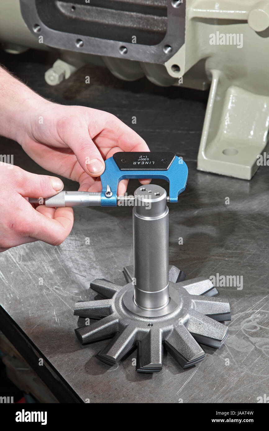 An engineer uses a micrometer to measure the diameter of components