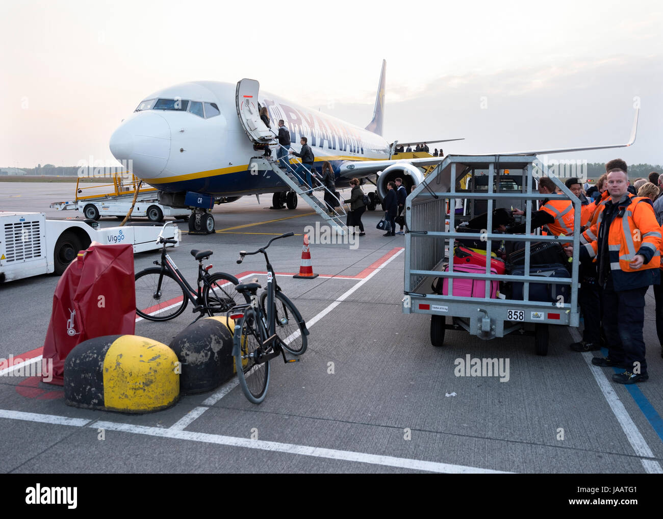 Eindhoven, Netherlands, 5 may 2017: luggage and bicycles waiting while passengers board ryanair airplane on eindhoven airport in the netherlands Stock Photo