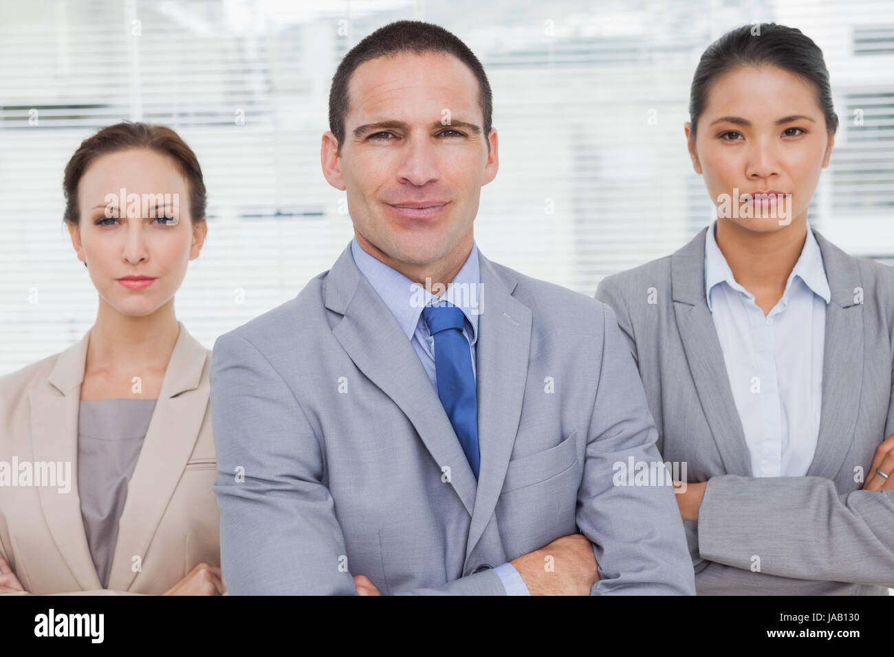 Serious partners posing crossing arms in bright office Stock Photo - Alamy