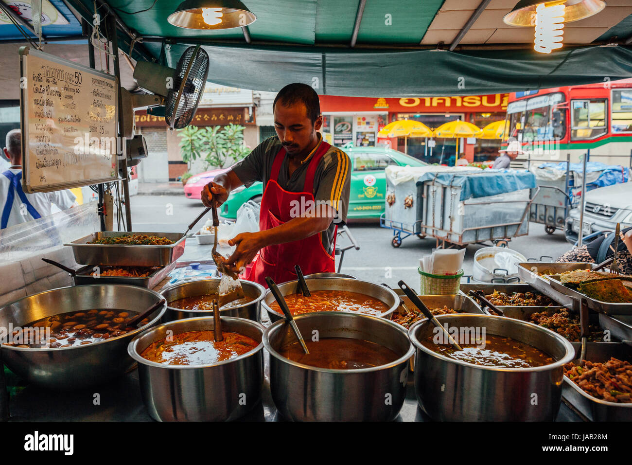 Bangkok, Thailand September 11, 2016 Street vendor pouring curry in