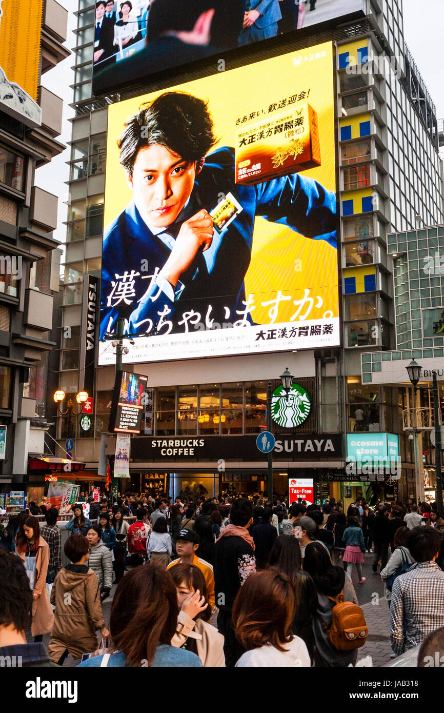 Dotonbori in Osaka. Crowded street at twilight evening time. Starbucks coffee shop with 4 storey