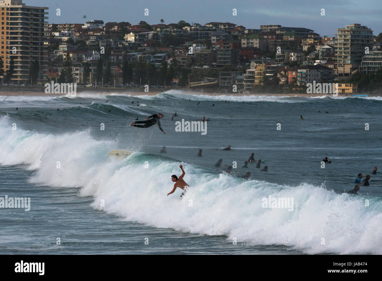 Dramatic scene with surfer flying high in the air at Manly beach, Sydney, New South Wales, Australia Stock Photo
