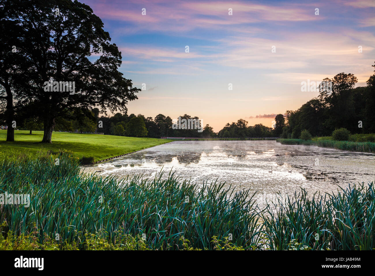 A summer sunrise over the lake at Lydiard Park in Swindon, Wiltshire. Stock Photo