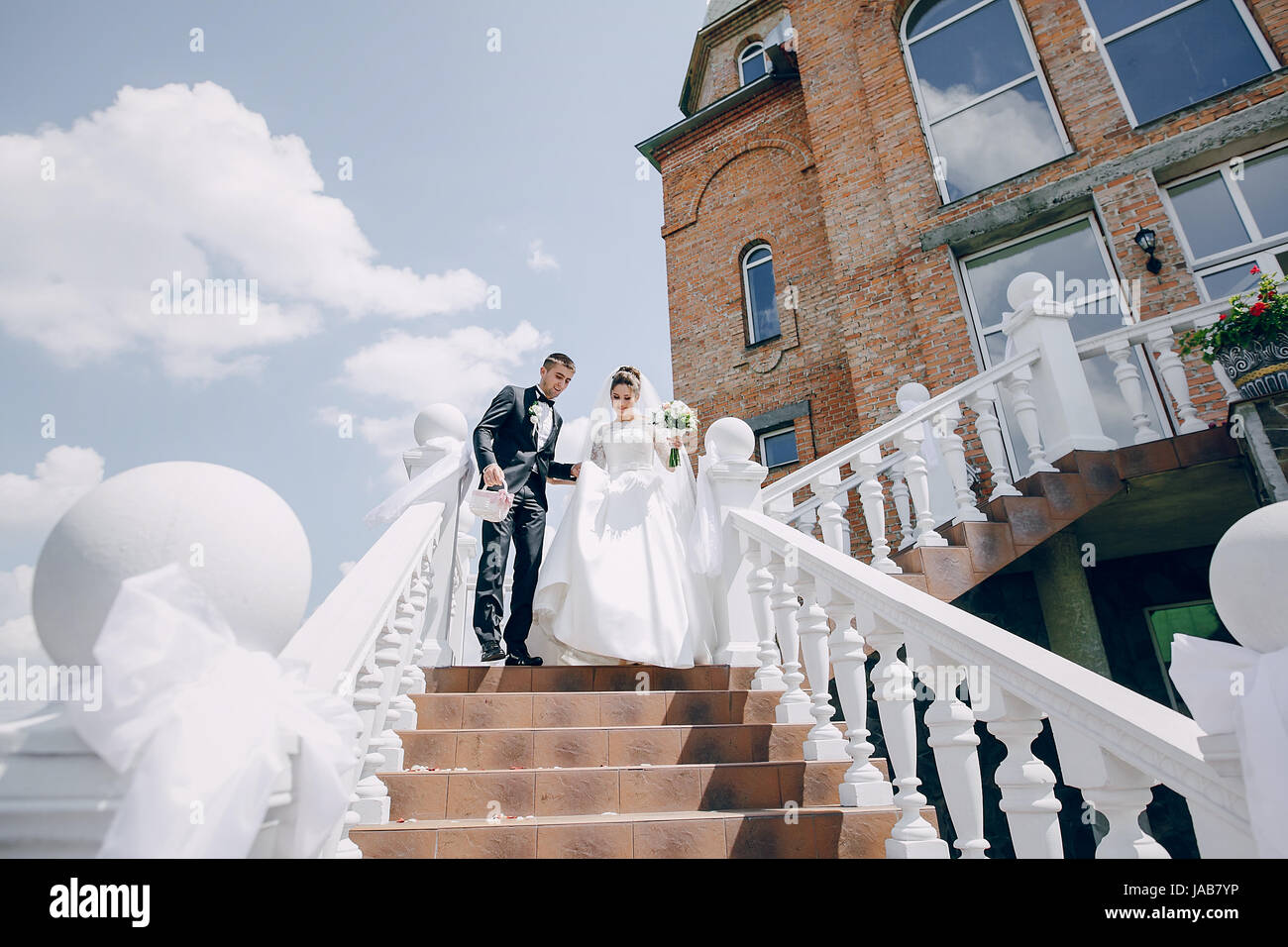 the bride and groom stand near the big house and windows Stock Photo ...