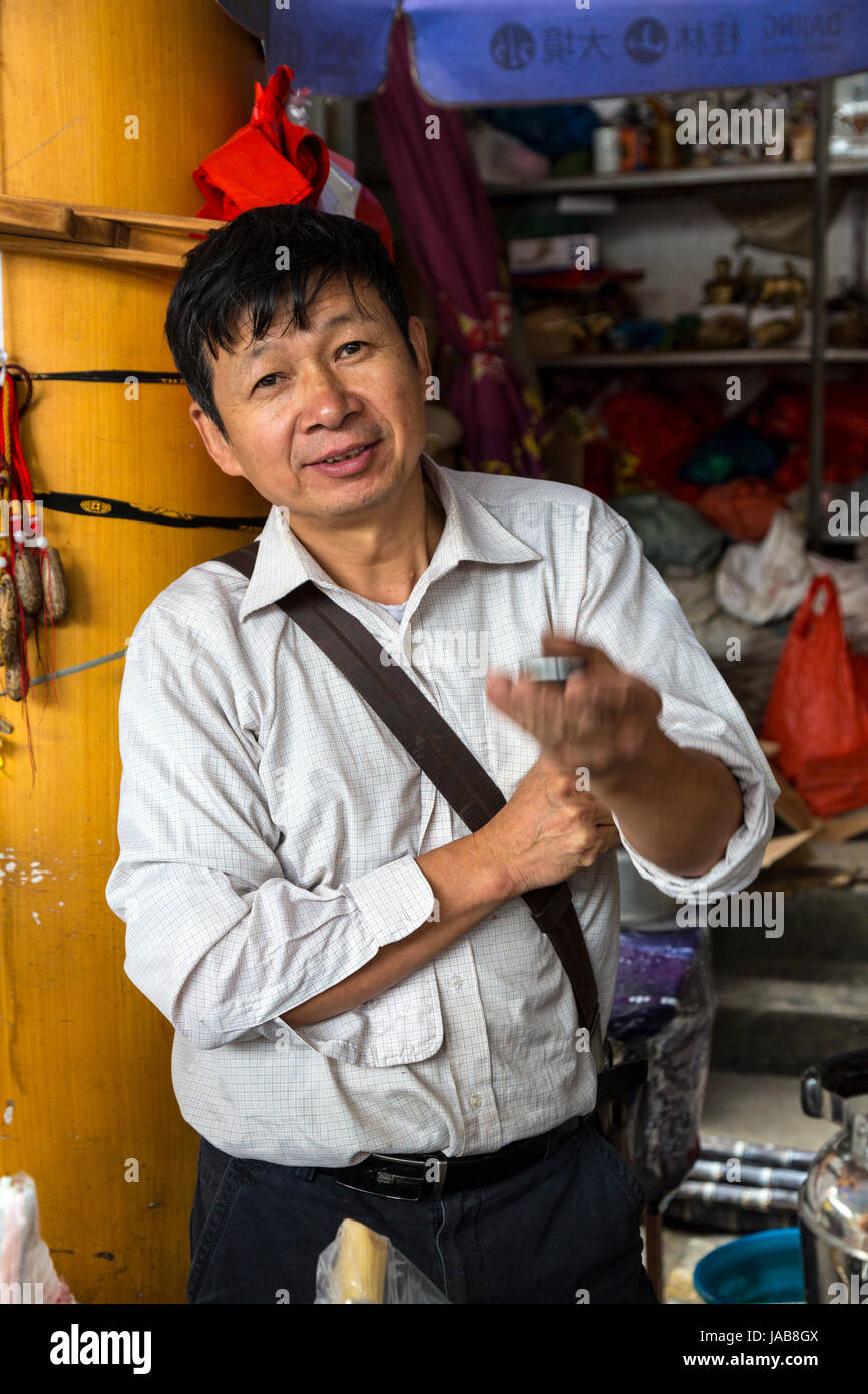 Yangshuo, China.  Vendor Tossing a Toy in the Air, to Attract a Buyer. Stock Photo