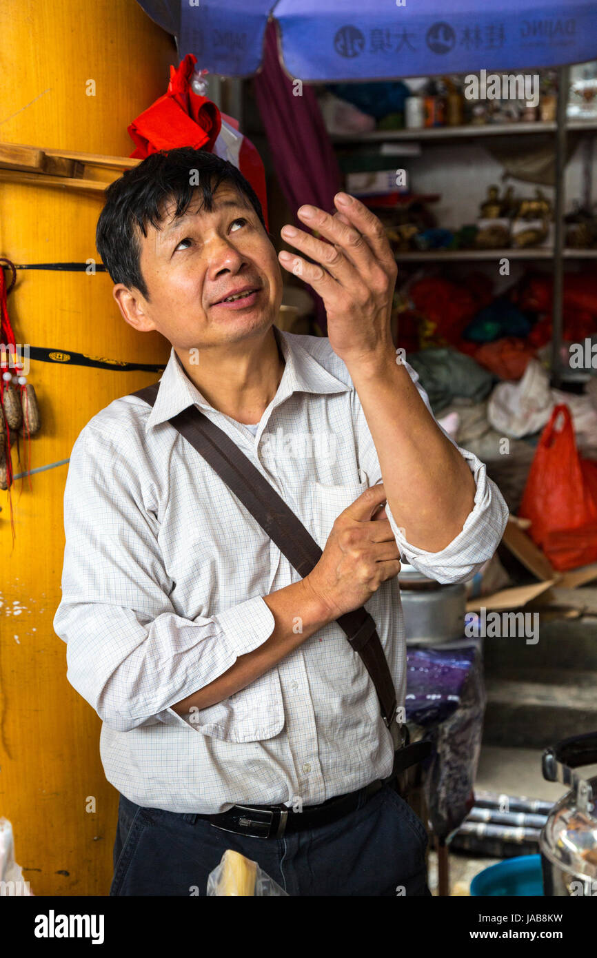 Yangshuo, China.  Vendor Tossing a Toy in the Air, to Attract a Buyer. Stock Photo